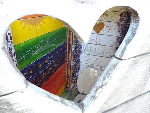 Окошко в туалет в форме сердечка, с весёлыми внутренними стенами. Дом Иштвана Napfényszentély в Венгрии в Szentbékkállá.