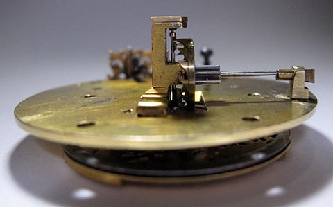 Side view showing the verge pallets engaging the teeth of the escape wheel. Antique table clock with fusee and chain.