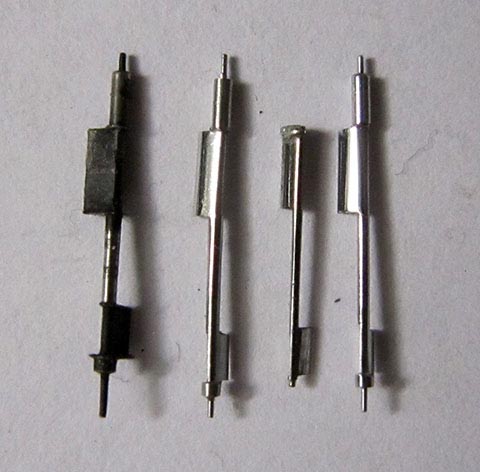 Manufacturing the balance staff. Three newly crafted balance staffs with rounded pallet faces next to the broken original. Antique verge escapement clock.