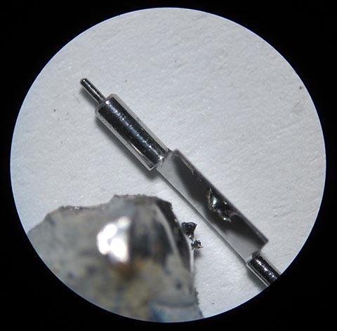 Manufacturing the balance staff. A piece of tin reflecting in the polished pallet face of the balance staff. Antique verge escapement table clock.