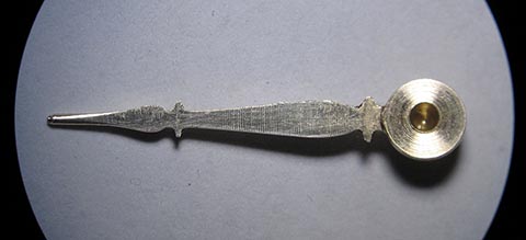 Manufacturing the minute hand. Flat side with a drilled hole for the cannon pinion. Antique verge escapement table clock.