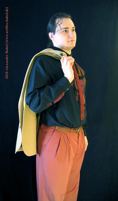 Александр Бабель крупным планом в полный рост с пиджаком, закинутым за плечи.