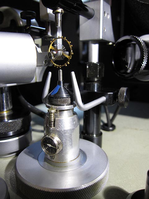 Jean Widmer-Steiner для уравновешивания винтового баланса Тип 1. Крупным планом операция уравновешивания баланса в станке. Измеритель глубины сверления.