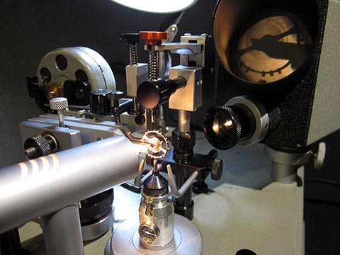 Jean Widmer-Steiner для уравновешивания винтового баланса Тип 1. С помощью луча света чёрный силуэт баланса проецируется на маленький экран.