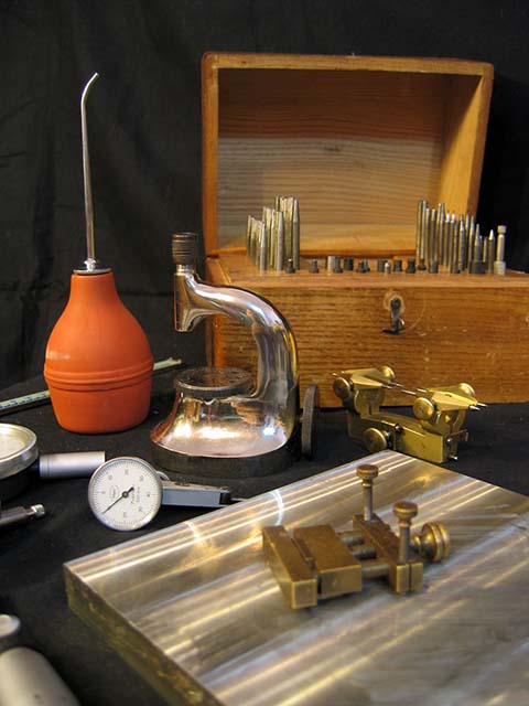 Специальный часовой инструмент: приспособление для прессования камней, ящик с пунциями, циркуль зацепления, груша, оловянный брус, микрометр и др.